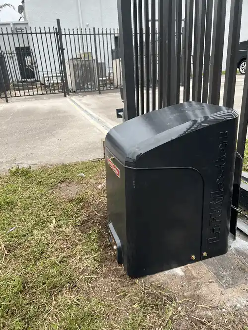 Black LiftMaster slide gate operator beside a metal fence